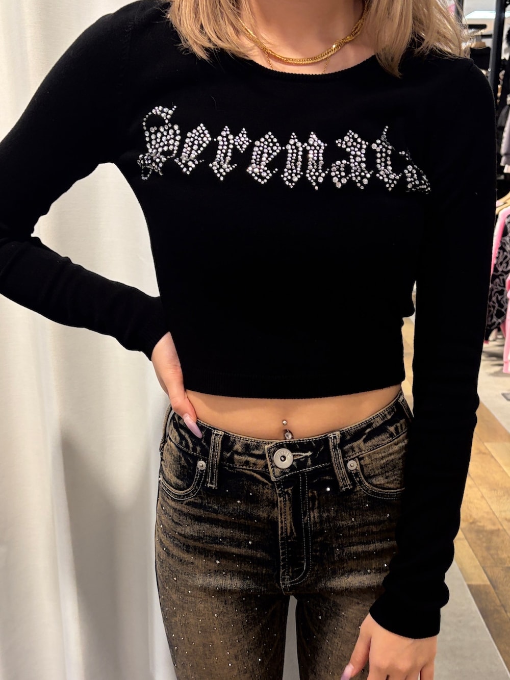 ブラック系のニット/セーター、ブルー系のデニムパンツ、ブラック系のブーツを着用したレディースの冬コーディネートの4枚目の写真