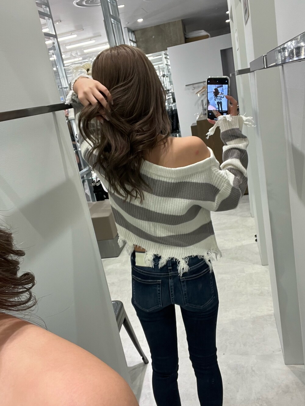 グレー系のニット/セーター、ブルー系のデニムパンツ、ホワイト系のパンプスを着用したレディースの夏コーディネートの3枚目の写真