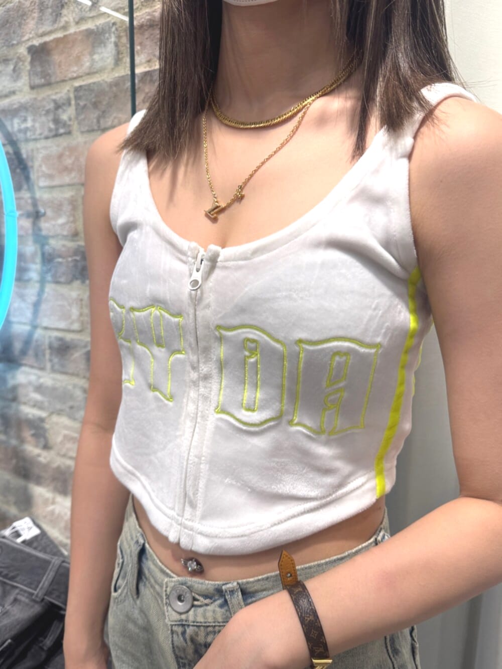 ブラック系のサンダル、ホワイト系のキャミソール、ブルー系のデニムパンツを着用したレディースの夏コーディネートの4枚目の写真