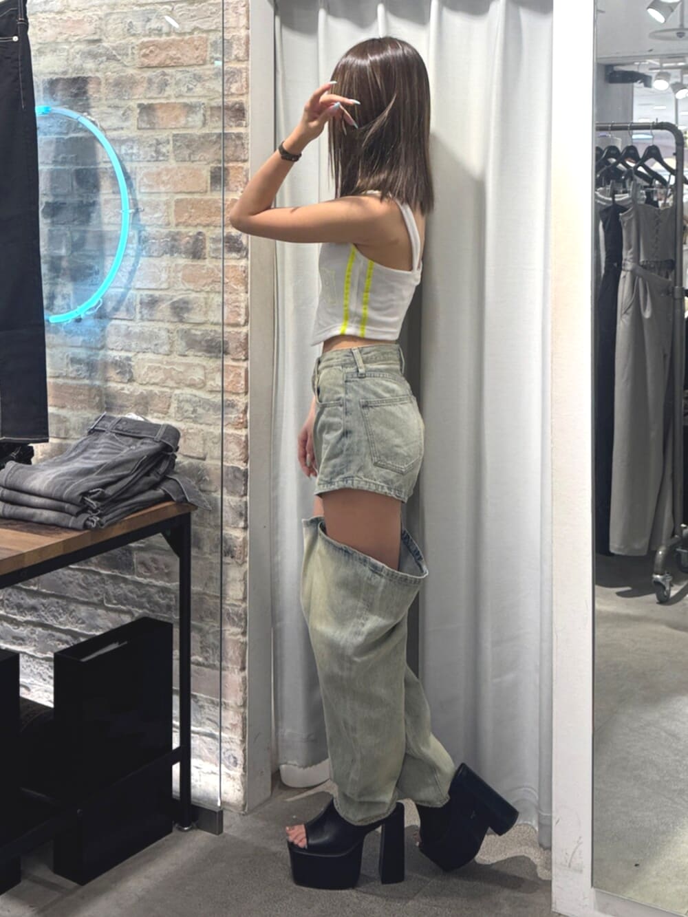 ブラック系のサンダル、ホワイト系のキャミソール、ブルー系のデニムパンツを着用したレディースの夏コーディネートの2枚目の写真