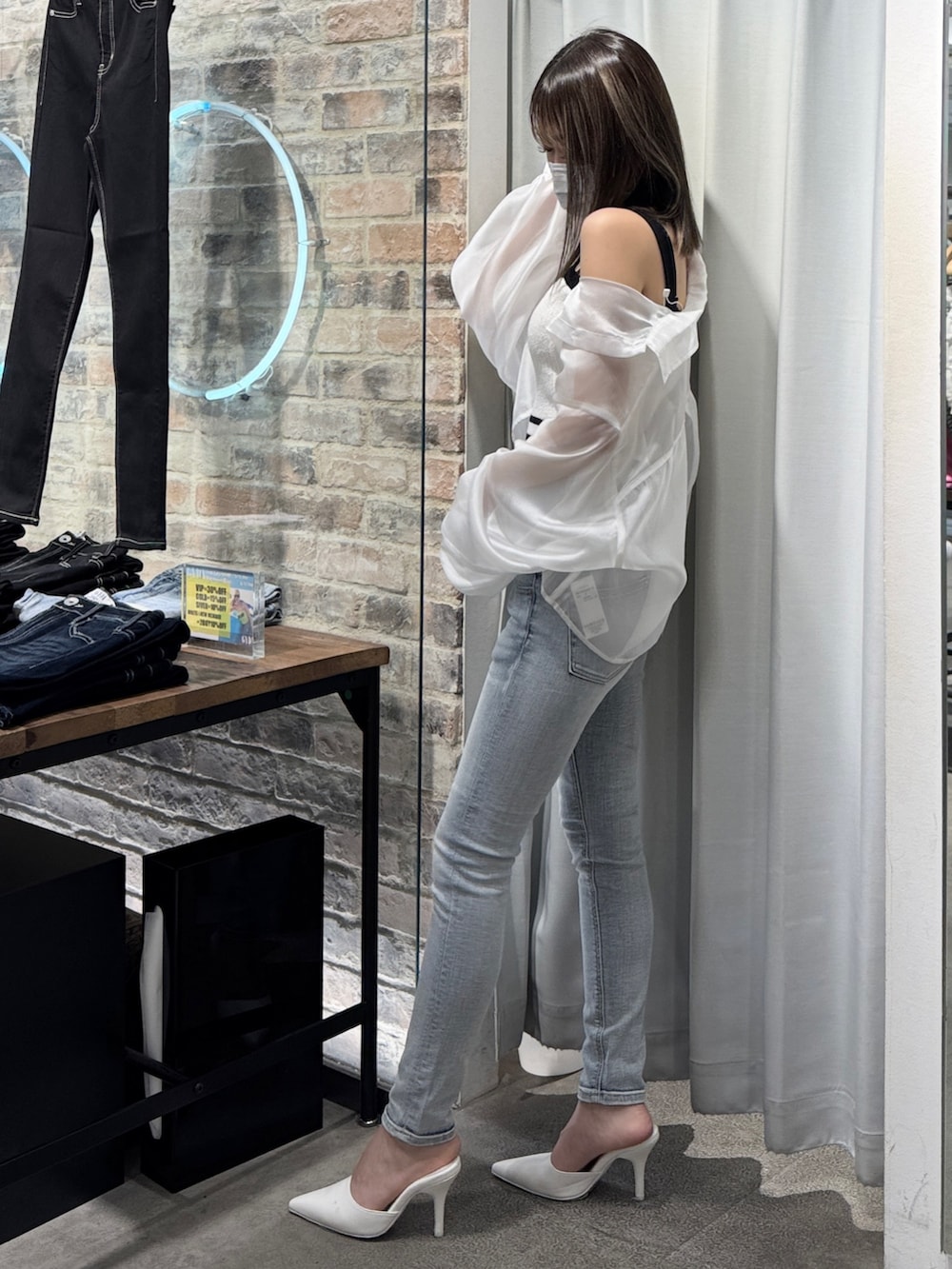 ホワイト系のキャミソール、ブルー系のデニムパンツ、ホワイト系のパンプスを着用したレディースの春コーディネートの3枚目の写真