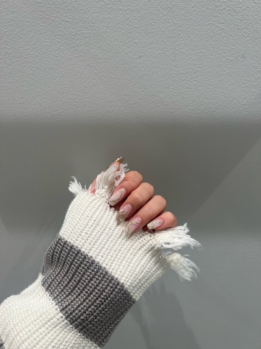 グレー系のニット/セーター、ブルー系のデニムパンツ、ホワイト系のパンプスを着用したレディースの夏コーディネートの4枚目の写真