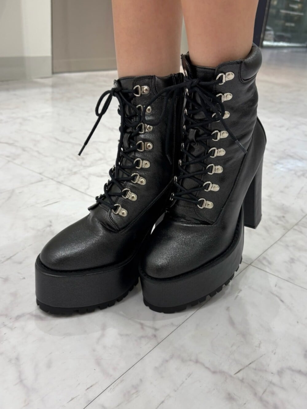 ブラック系のブーツ、ブラック系のその他アウター、ブラック系のワンピースを着用したレディースの春コーディネートの5枚目の写真