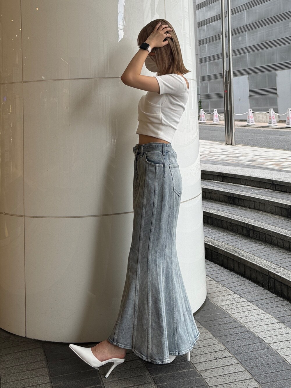 ホワイト系のTシャツ/カットソー、ブルー系のデニムスカート、ホワイト系のパンプスを着用したレディースの夏コーディネートの3枚目の写真