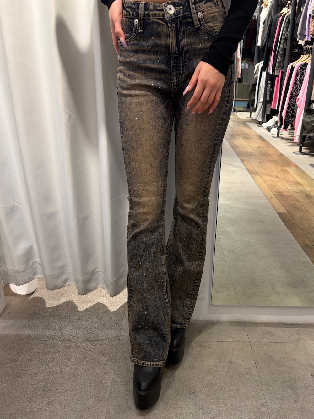 ブラック系のニット/セーター、ブルー系のデニムパンツ、ブラック系のブーツを着用したレディースの冬コーディネートの5枚目の写真