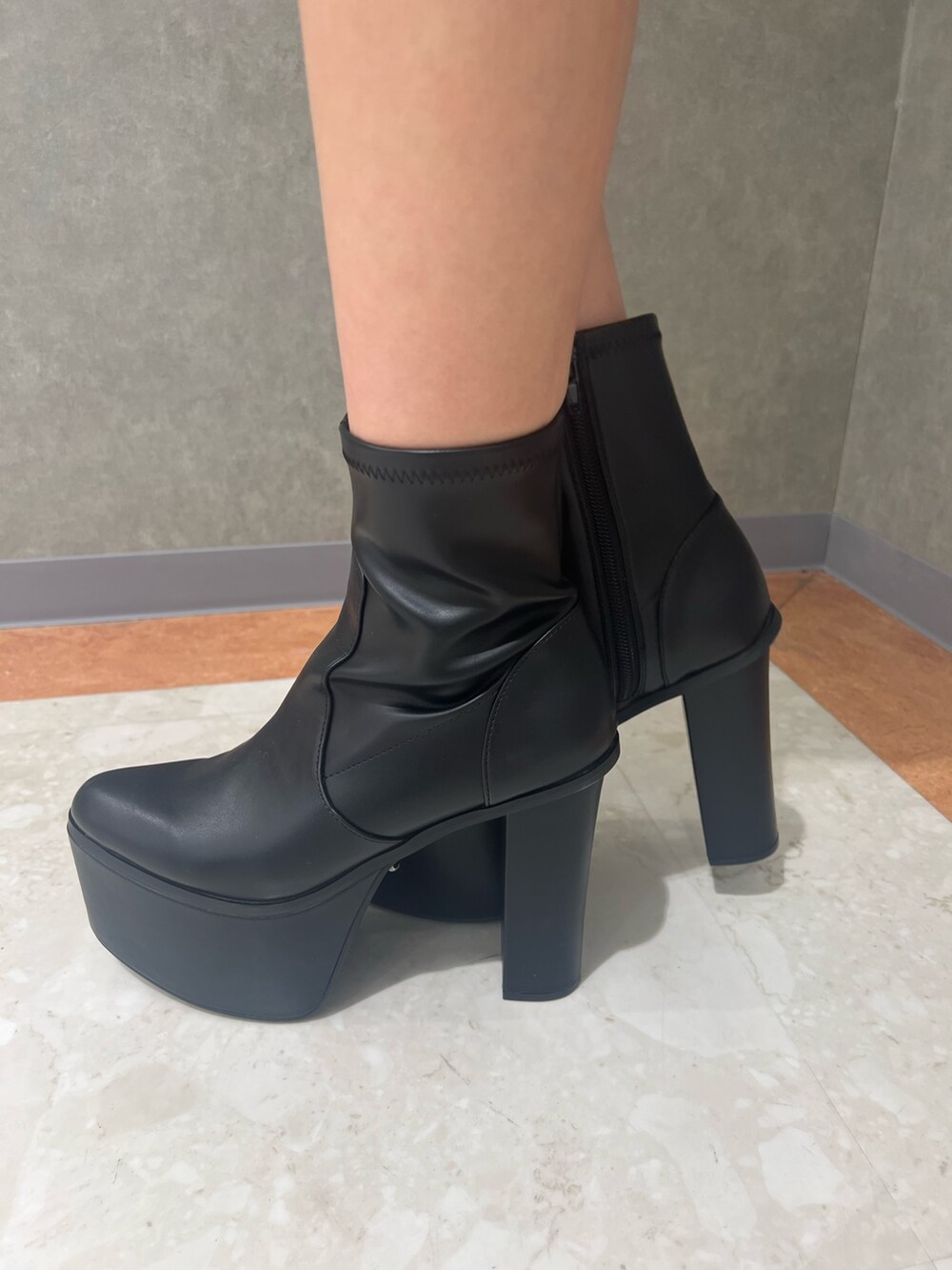 ホワイト系のニット/セーター、ブラック系のスカート、ブラック系のブーツを着用したレディースの冬コーディネートの6枚目の写真