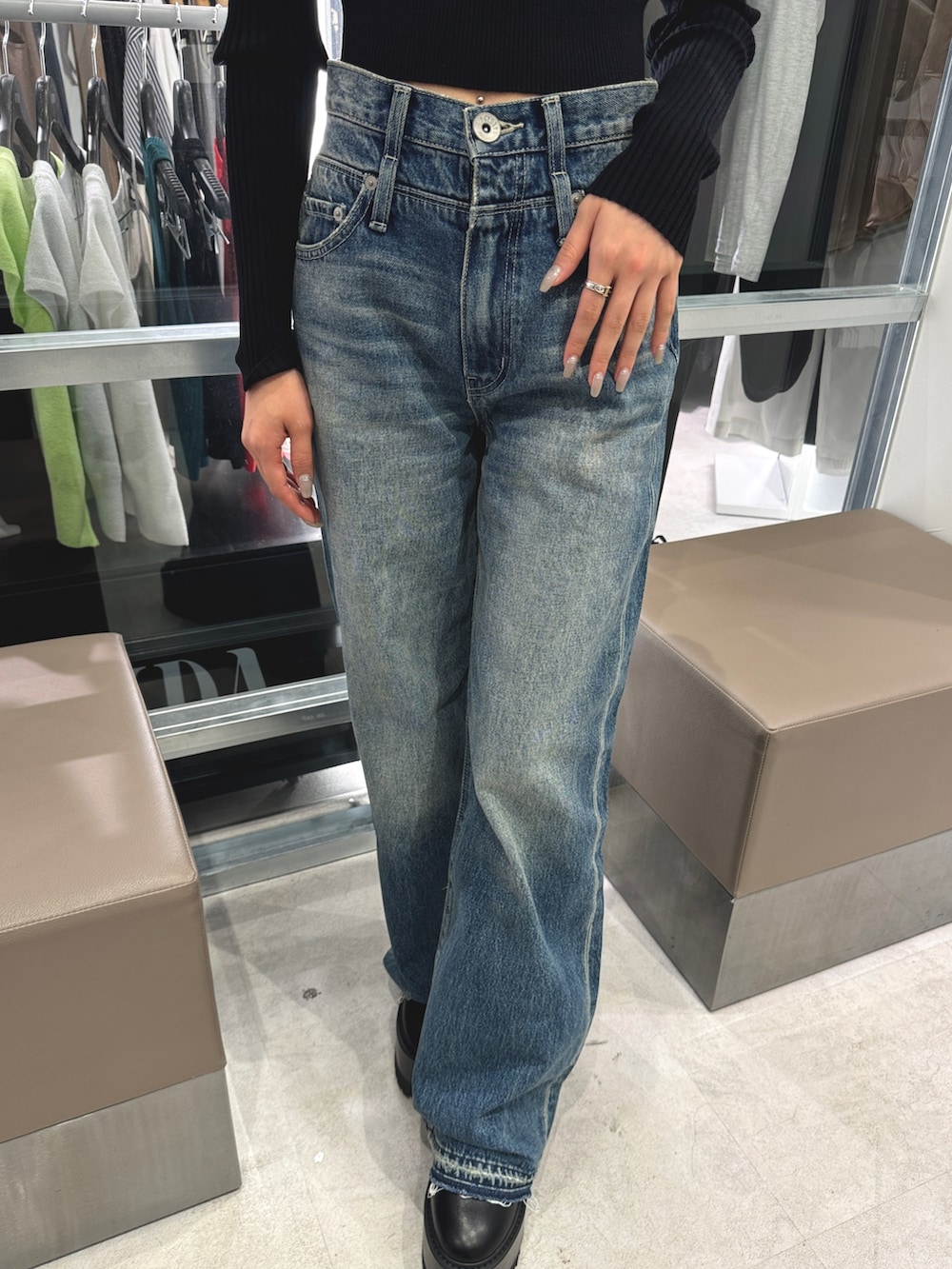 ブラック系のニット/セーター、ブルー系のデニムパンツ、ブラック系のブーツを着用したレディースの秋コーディネートの6枚目の写真