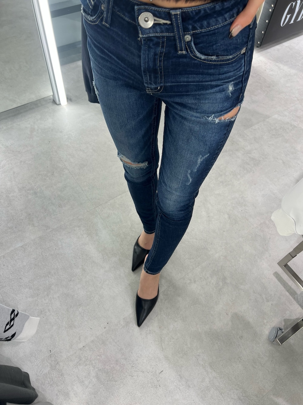 ブラック系のニット/セーター、ブルー系のデニムパンツ、ブラック系のパンプスを着用したレディースの秋コーディネートの4枚目の写真