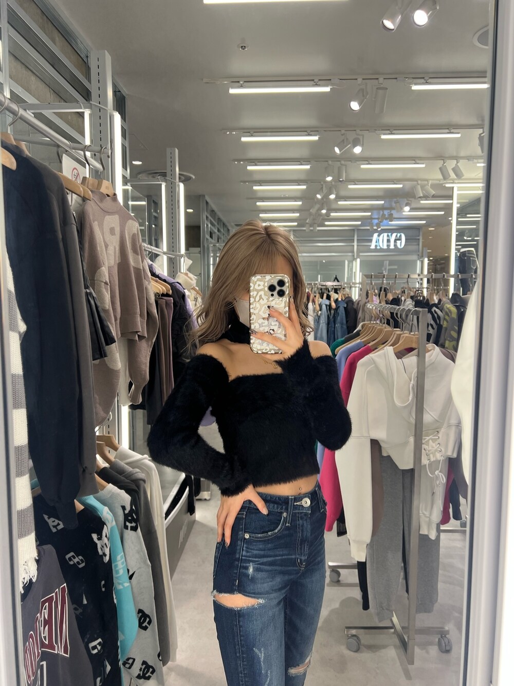 ブラック系のニット/セーター、ブルー系のデニムパンツ、ブラック系のパンプスを着用したレディースの秋コーディネートの2枚目の写真