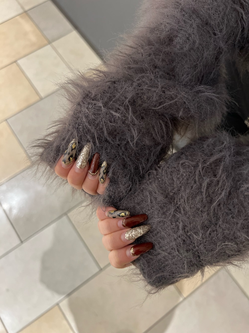 グレー系のニット/セーター、ブラック系のデニムパンツ、ホワイト系のパンプスを着用したレディースの冬コーディネートの4枚目の写真