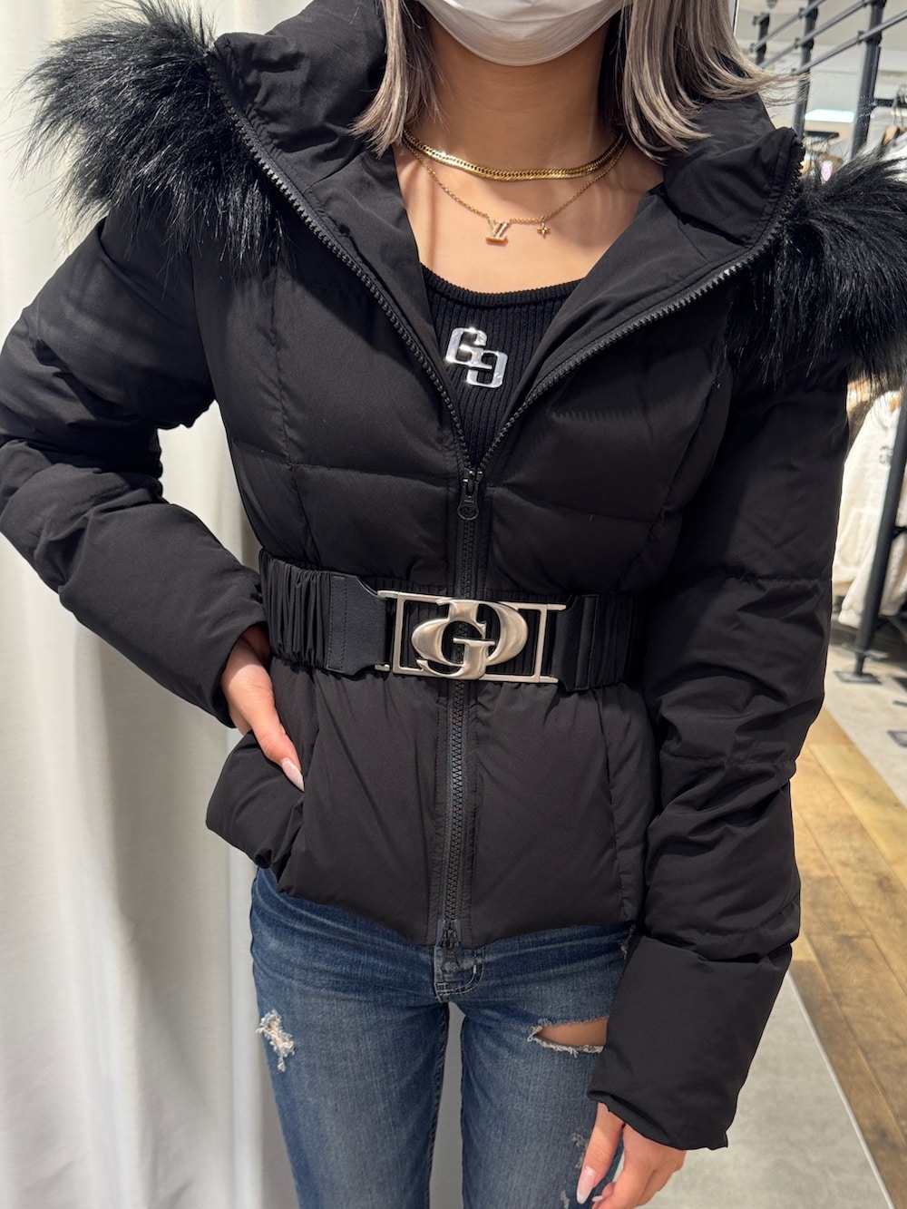 ブラック系のダウンジャケット/コート、ブルー系のデニムパンツ、ブラック系のブーツを着用したレディースの秋コーディネートの4枚目の写真