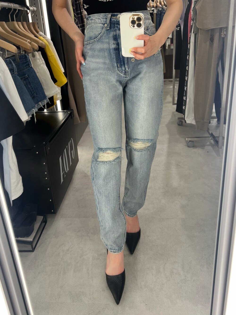 ブラック系のニット/セーター、ブルー系のデニムパンツ、ブラック系のパンプスを着用したレディースの春コーディネートの4枚目の写真