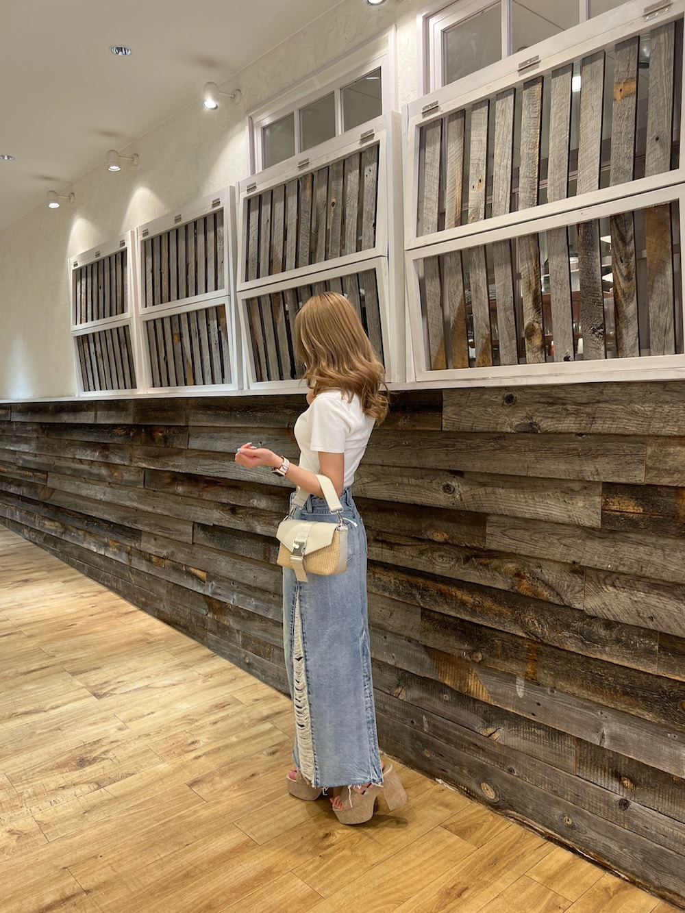 ホワイト系のサンダル、ブルー系のデニムスカート、ホワイト系のニット/セーターを着用したレディースの春コーディネートの2枚目の写真