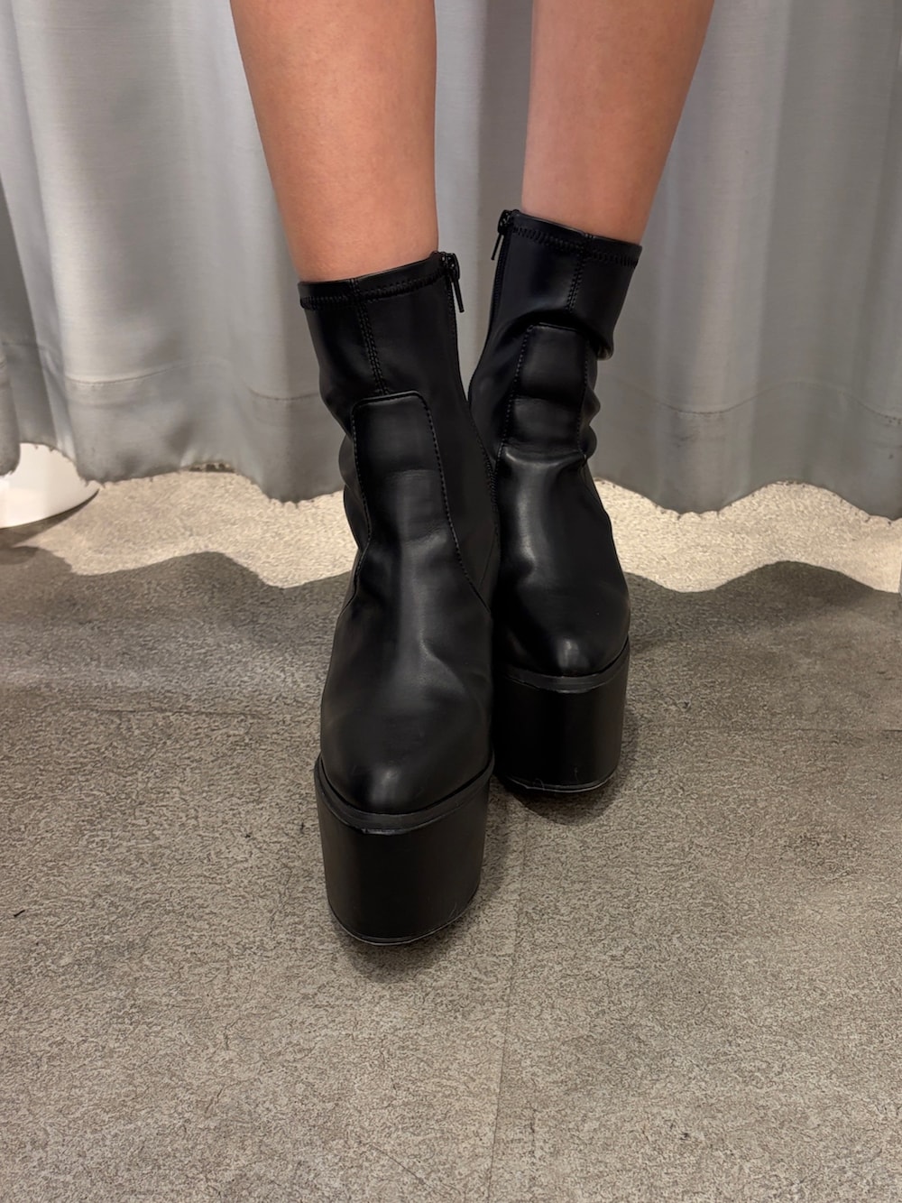 ホワイト系のワンピース、ブラック系のブーツを着用したレディースの冬コーディネートの5枚目の写真