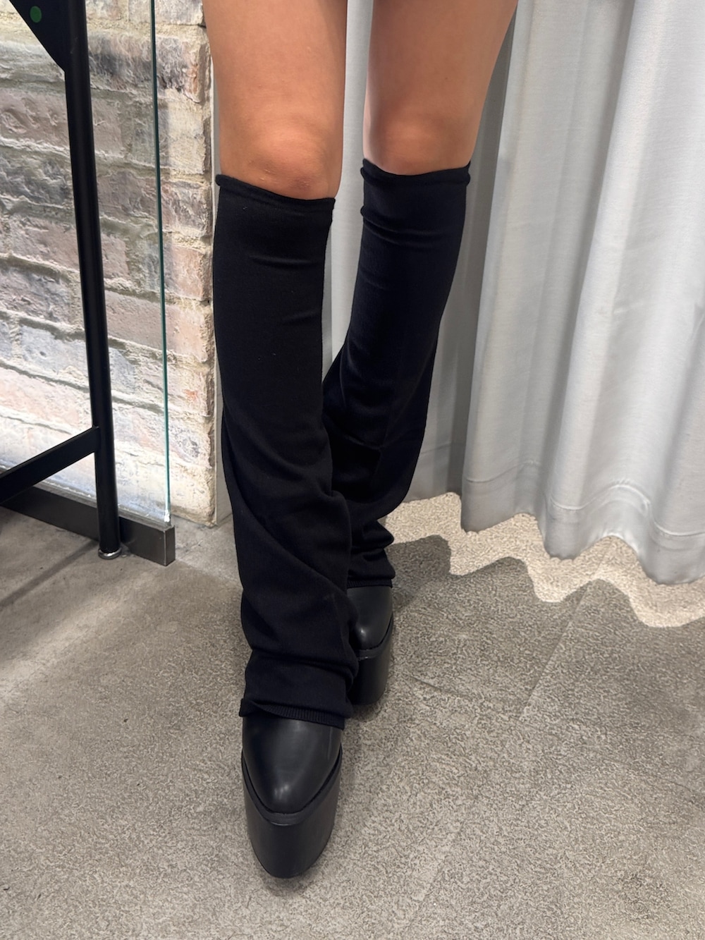 ブラック系のワンピース、ブラック系のブーツを着用したレディースの夏コーディネートの5枚目の写真