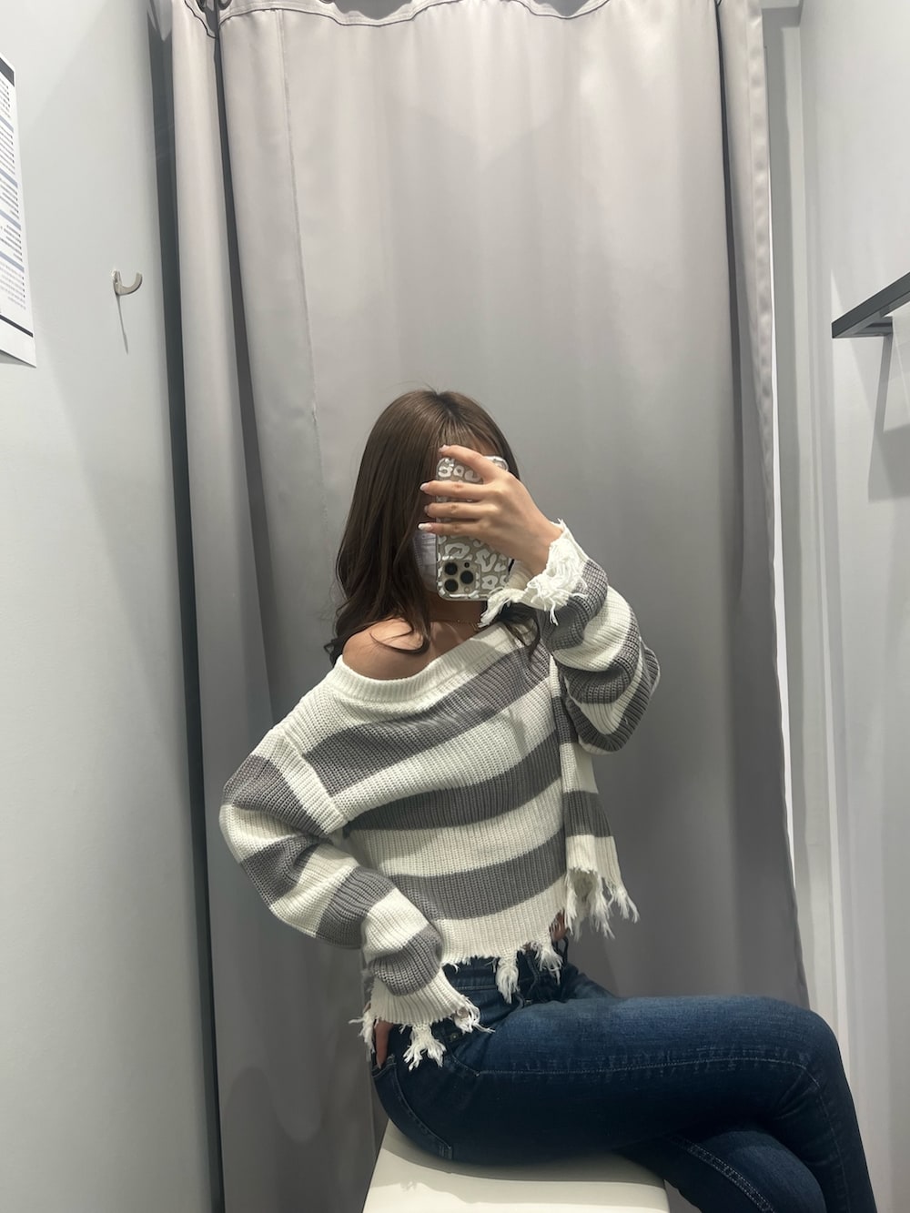 グレー系のニット/セーター、ブルー系のデニムパンツ、ホワイト系のパンプスを着用したレディースの夏コーディネートの2枚目の写真