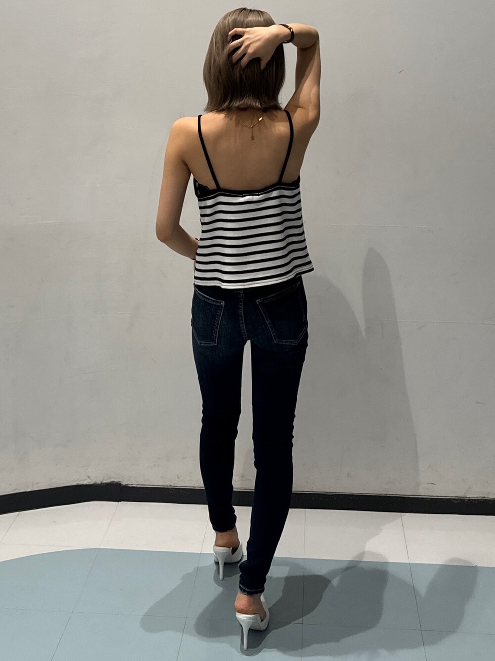 その他のキャミソール、ブルー系のデニムパンツ、ホワイト系のパンプスを着用したレディースの春コーディネートの3枚目の写真