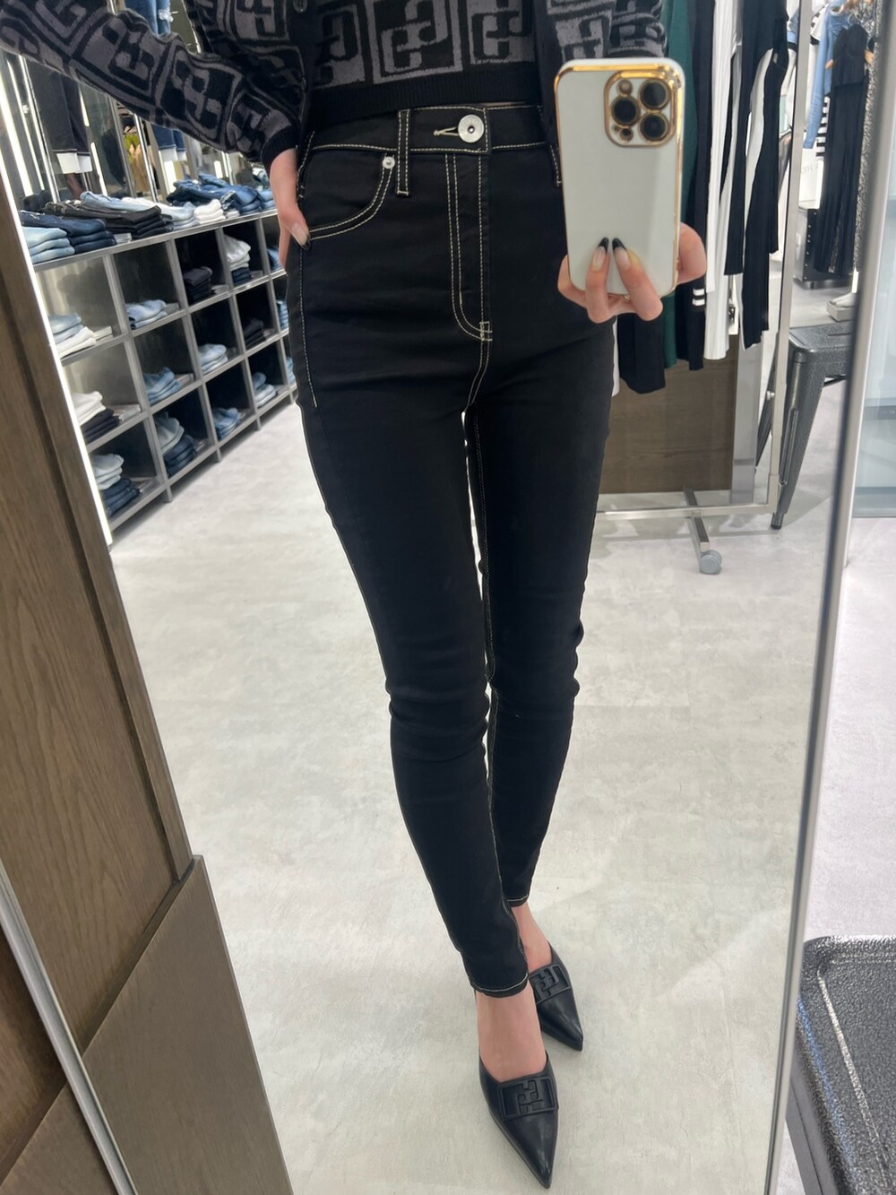 ブラック系のカーディガン/ボレロ、ブラック系のニット/セーター、ブラック系のデニムパンツを着用したレディースの春コーディネートの4枚目の写真