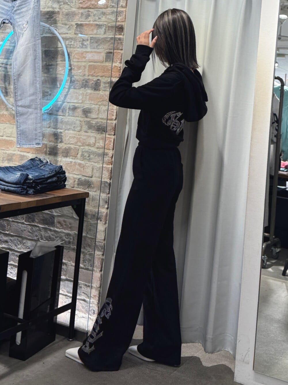 ホワイト系のパンプス、ブラック系のパーカー、ブラック系のスウェットパンツを着用したレディースの冬コーディネートの4枚目の写真