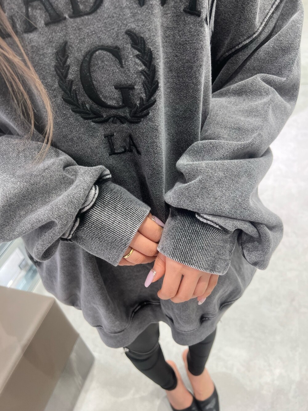 グレー系のスウェット、ブラック系のパンプス、ブラック系のレギンス/スパッツを着用したレディースの冬コーディネートの5枚目の写真