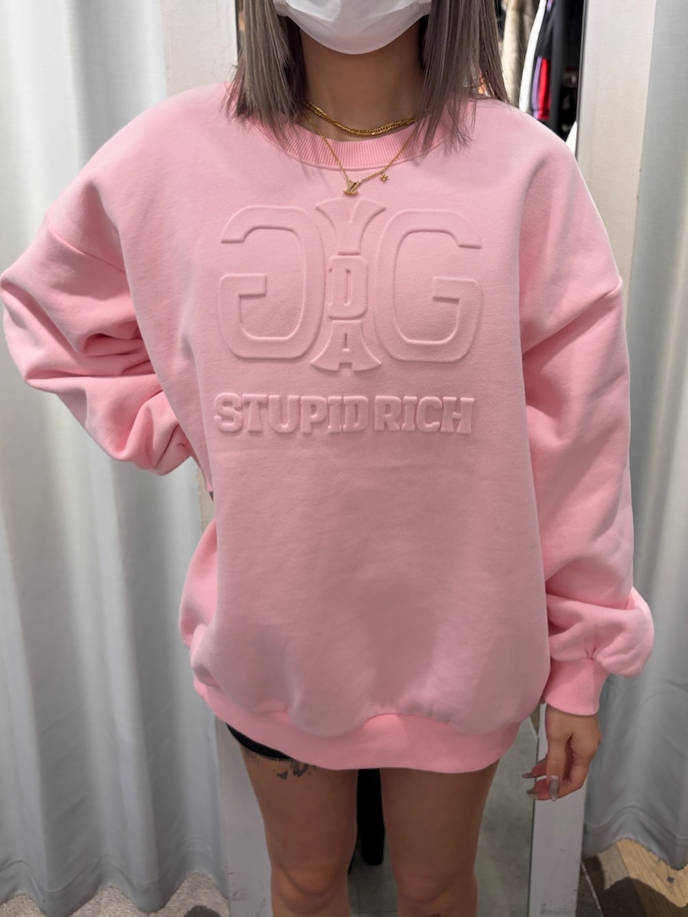 ピンク系のスウェット、ブラック系のブーツを着用したレディースの冬コーディネートの4枚目の写真