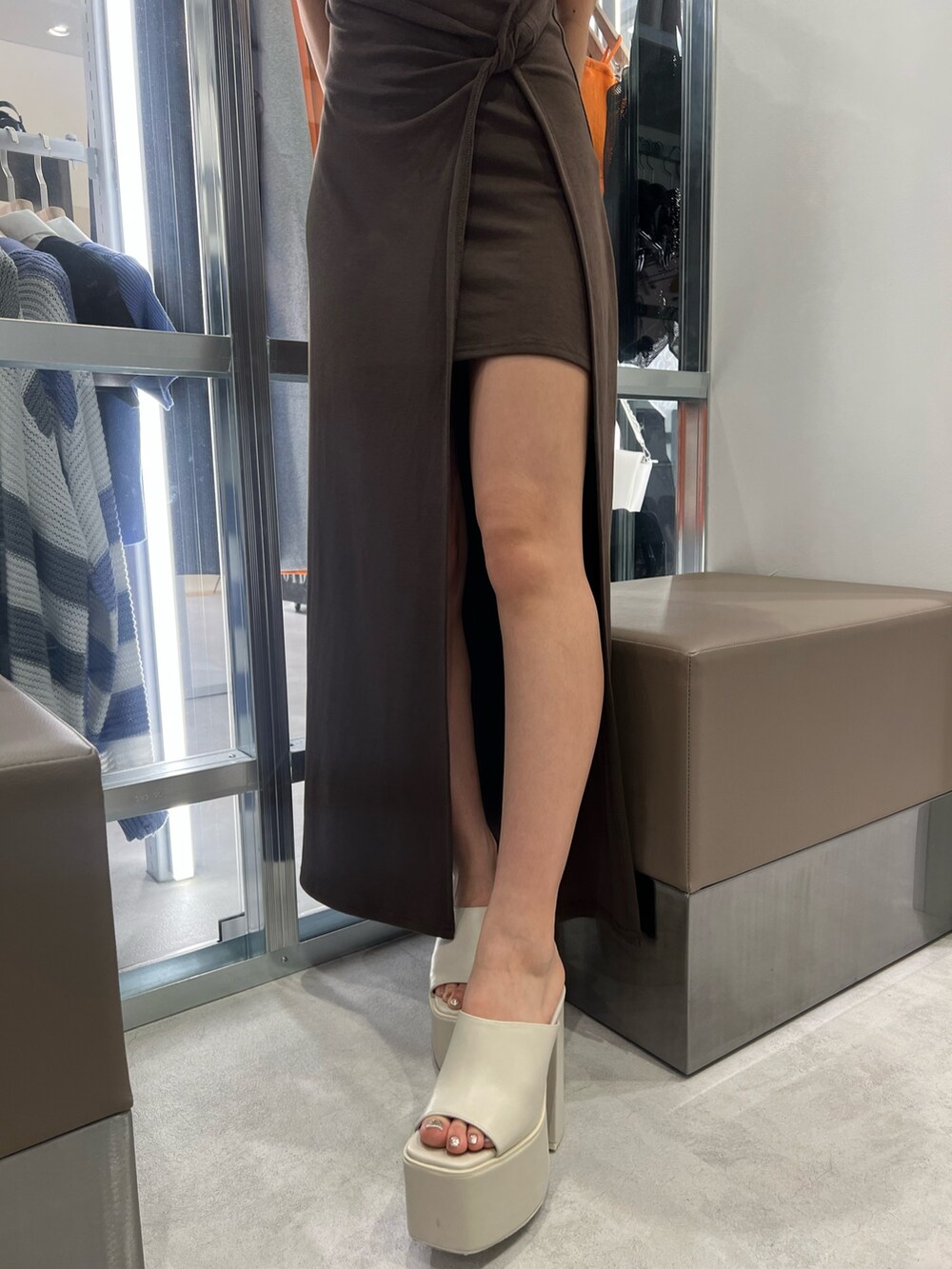 ブラウン系のワンピース、ホワイト系のハンドバッグ、ホワイト系のサンダルを着用したレディースの夏コーディネートの5枚目の写真