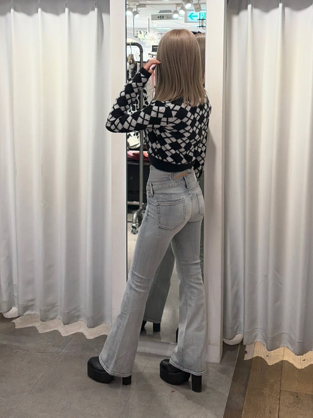 ブラック系のブーツ、ブルー系のデニムパンツ、ブラック系のキャミソールを着用したレディースの冬コーディネートの3枚目の写真