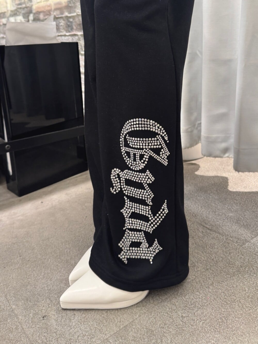 ホワイト系のパンプス、ブラック系のパーカー、ブラック系のスウェットパンツを着用したレディースの冬コーディネートの5枚目の写真