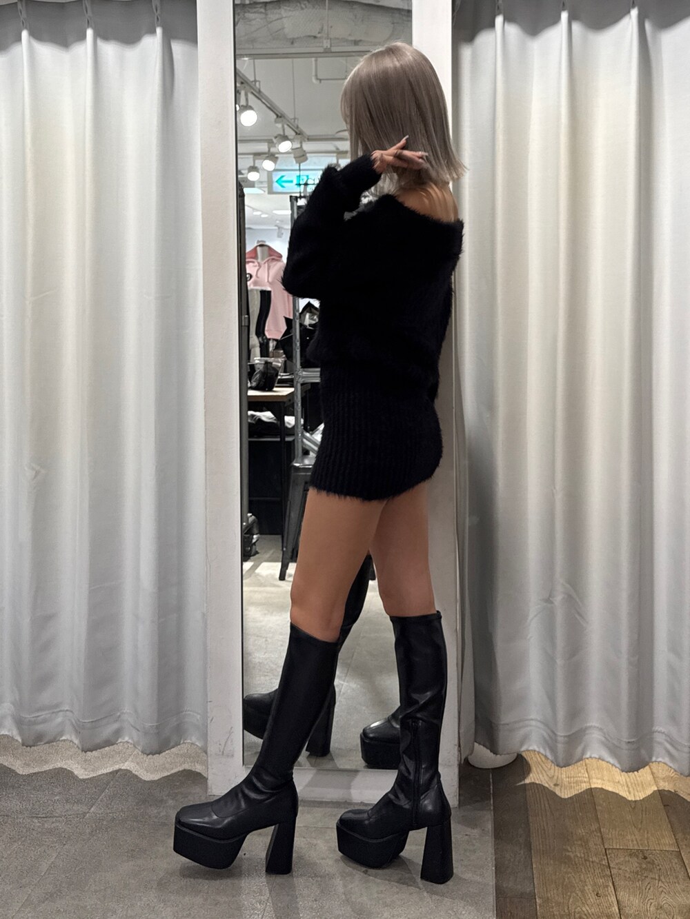 ブラック系のワンピース、ブラック系のブーツを着用したレディースの秋コーディネートの3枚目の写真