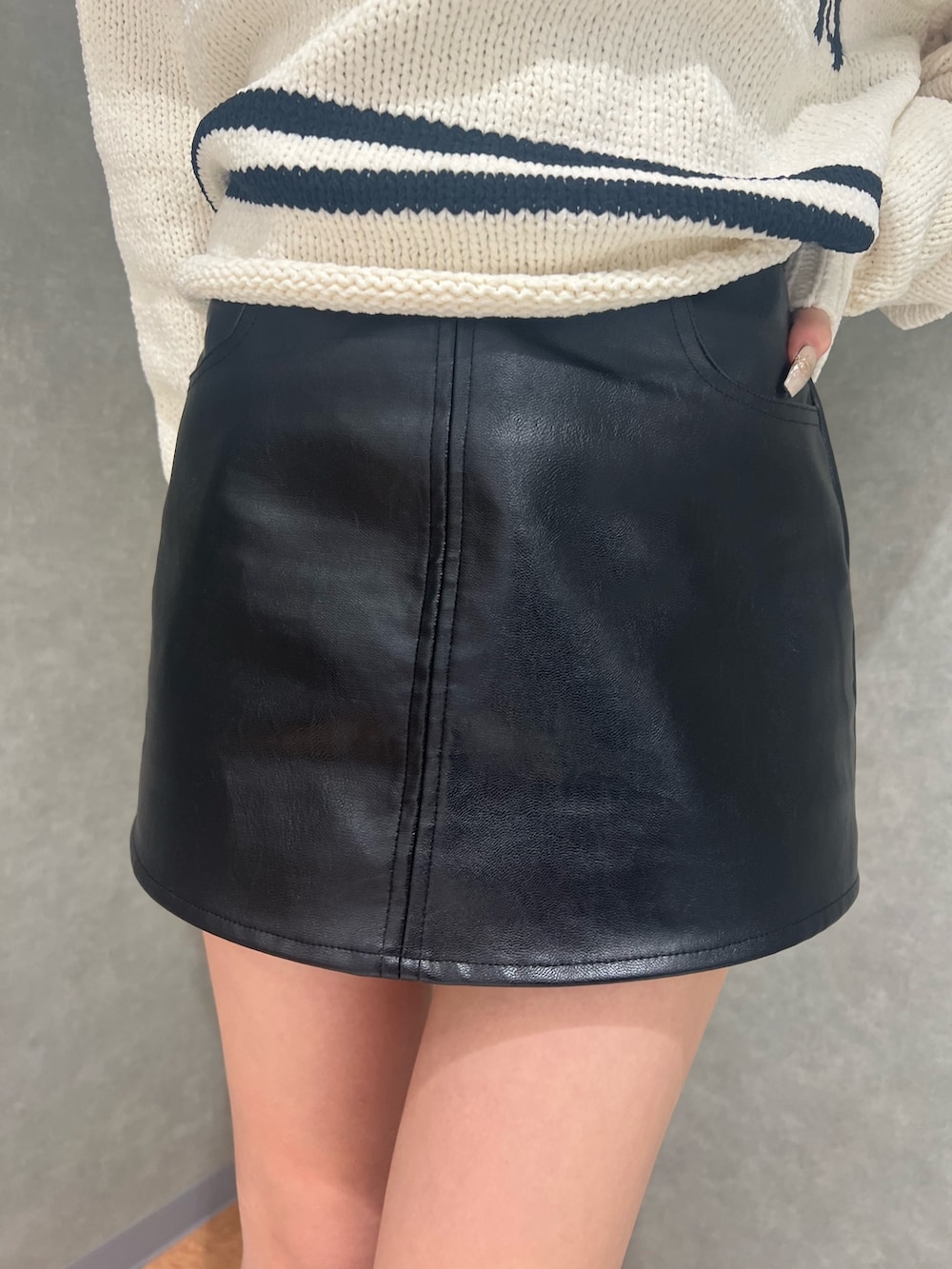 ホワイト系のニット/セーター、ブラック系のスカート、ブラック系のブーツを着用したレディースの冬コーディネートの5枚目の写真