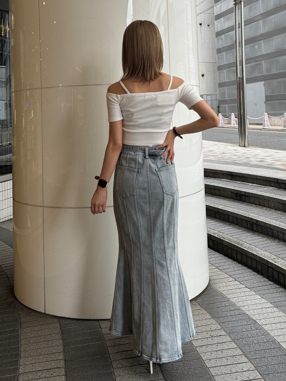 ホワイト系のTシャツ/カットソー、ブルー系のデニムスカート、ホワイト系のパンプスを着用したレディースの夏コーディネートの2枚目の写真