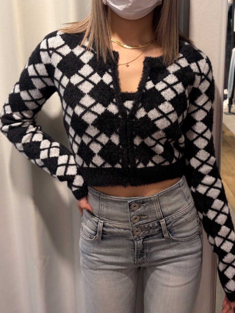 ブラック系のブーツ、ブルー系のデニムパンツ、ブラック系のキャミソールを着用したレディースの冬コーディネートの4枚目の写真