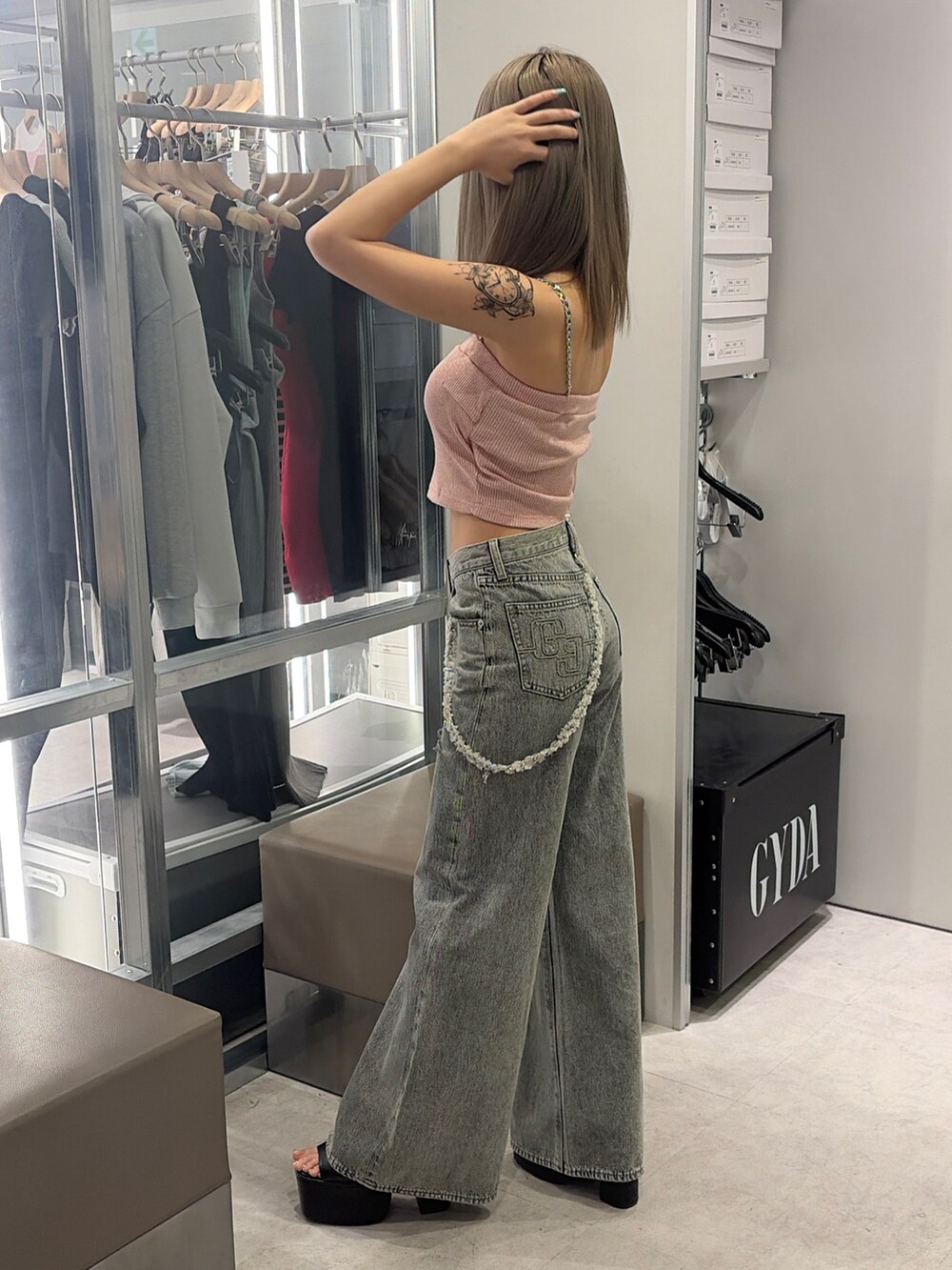 ピンク系のキャミソール、ブルー系のデニムパンツ、ブラック系のサンダルを着用したレディースの春コーディネートの3枚目の写真