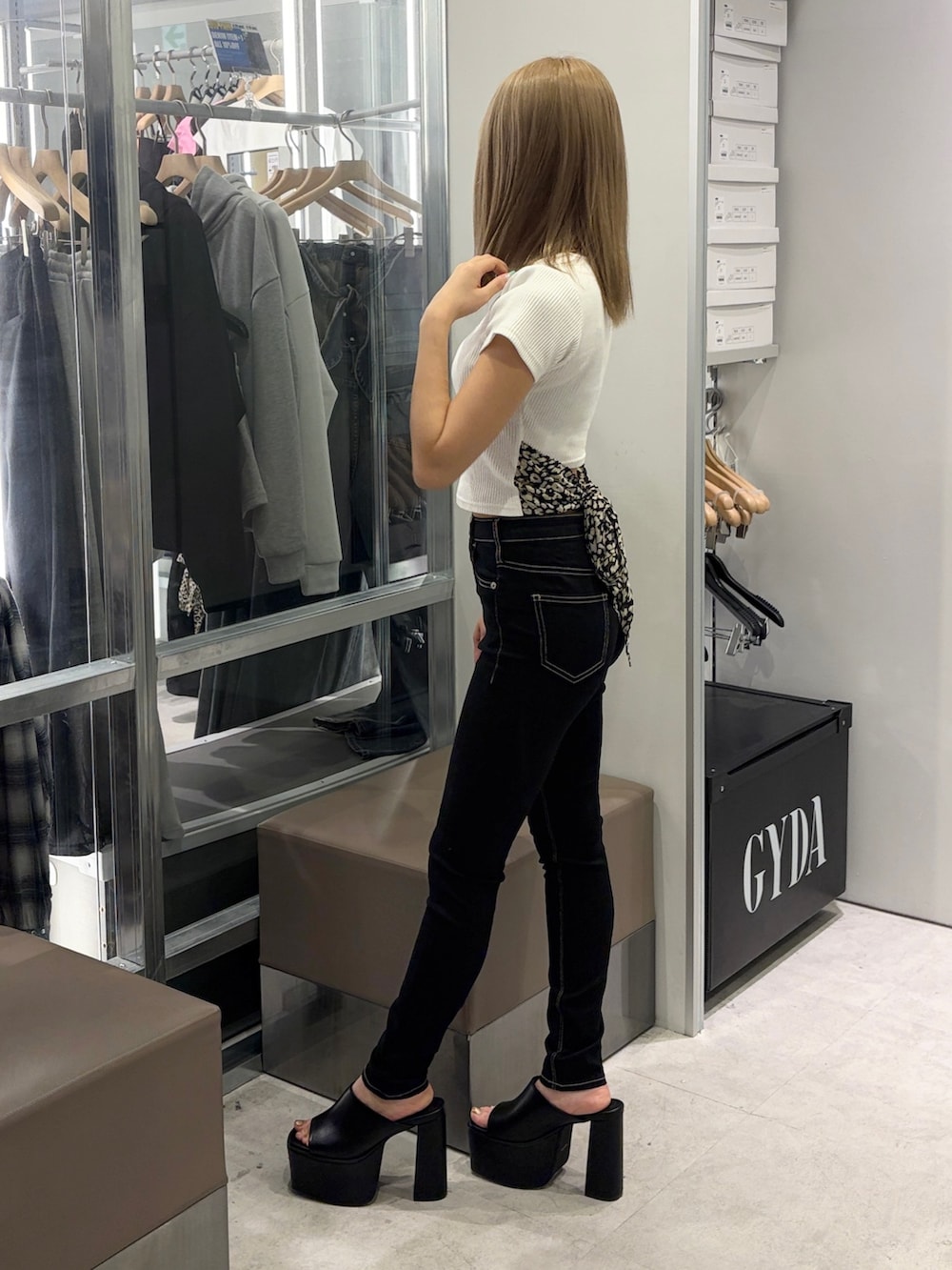 ホワイト系のTシャツ/カットソー、ブラック系のデニムパンツ、ブラック系のサンダルを着用したレディースの春コーディネートの3枚目の写真