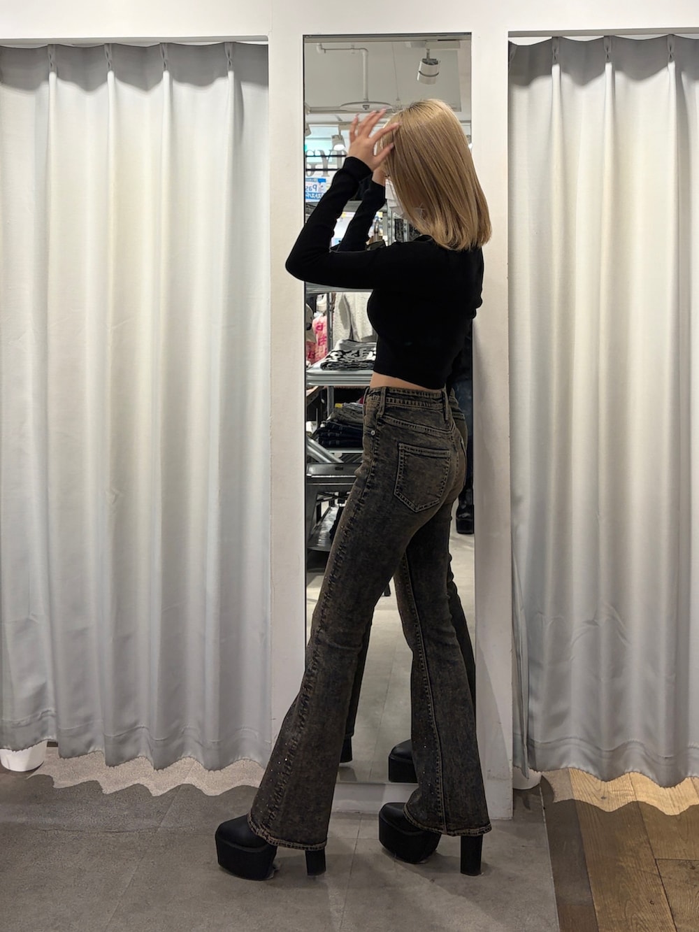 ブラック系のニット/セーター、ブルー系のデニムパンツ、ブラック系のブーツを着用したレディースの冬コーディネートの3枚目の写真