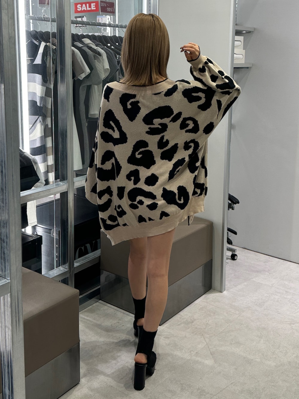 ブラック系のチューブトップ、ベージュ系のカーディガン/ボレロ、ブラック系のその他パンツを着用したレディースの夏コーディネートの3枚目の写真