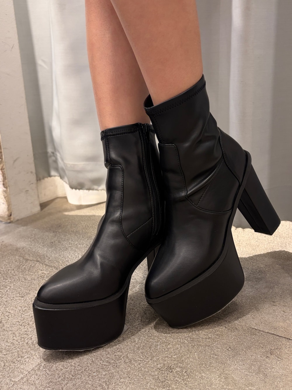 グレー系のパーカー、ブラック系のその他パンツ、ブラック系のブーツを着用したレディースの冬コーディネートの6枚目の写真