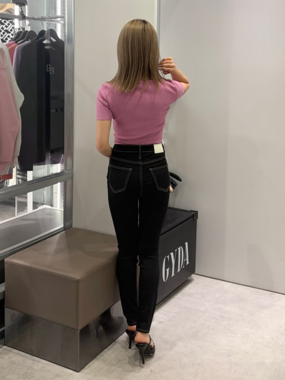 ブラック系のデニムパンツ、ピンク系のTシャツ/カットソー、ブラック系のパンプスを着用したレディースの春コーディネートの2枚目の写真