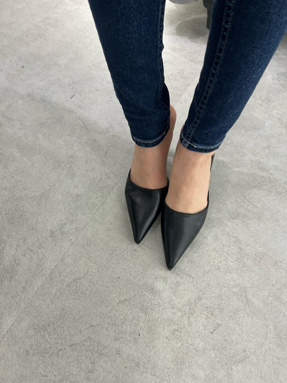 ブラック系のニット/セーター、ブルー系のデニムパンツ、ブラック系のパンプスを着用したレディースの秋コーディネートの5枚目の写真