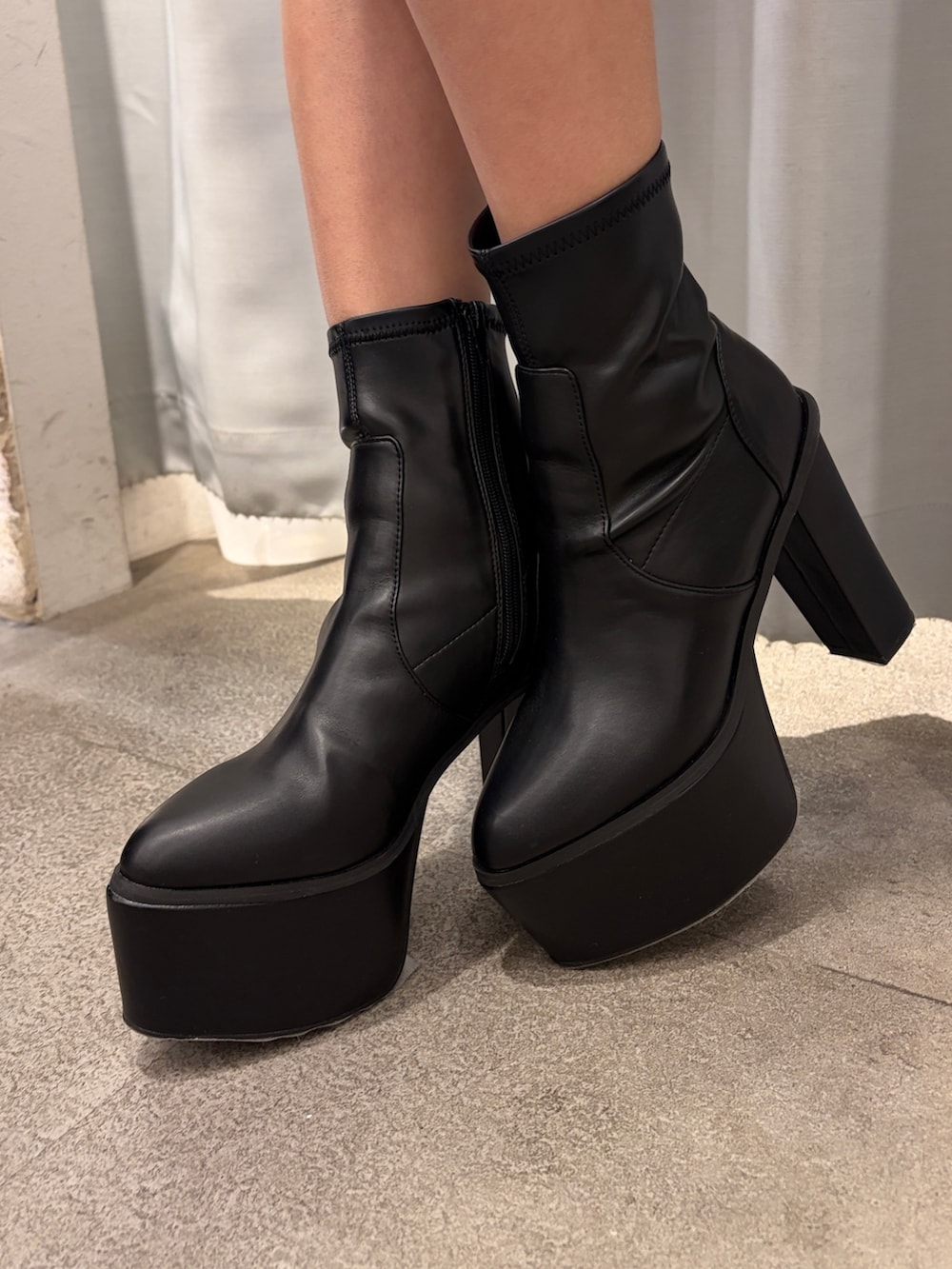 ピンク系のスウェット、ブラック系のブーツを着用したレディースの冬コーディネートの5枚目の写真