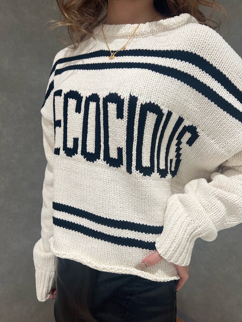 ホワイト系のニット/セーター、ブラック系のスカート、ブラック系のブーツを着用したレディースの冬コーディネートの3枚目の写真