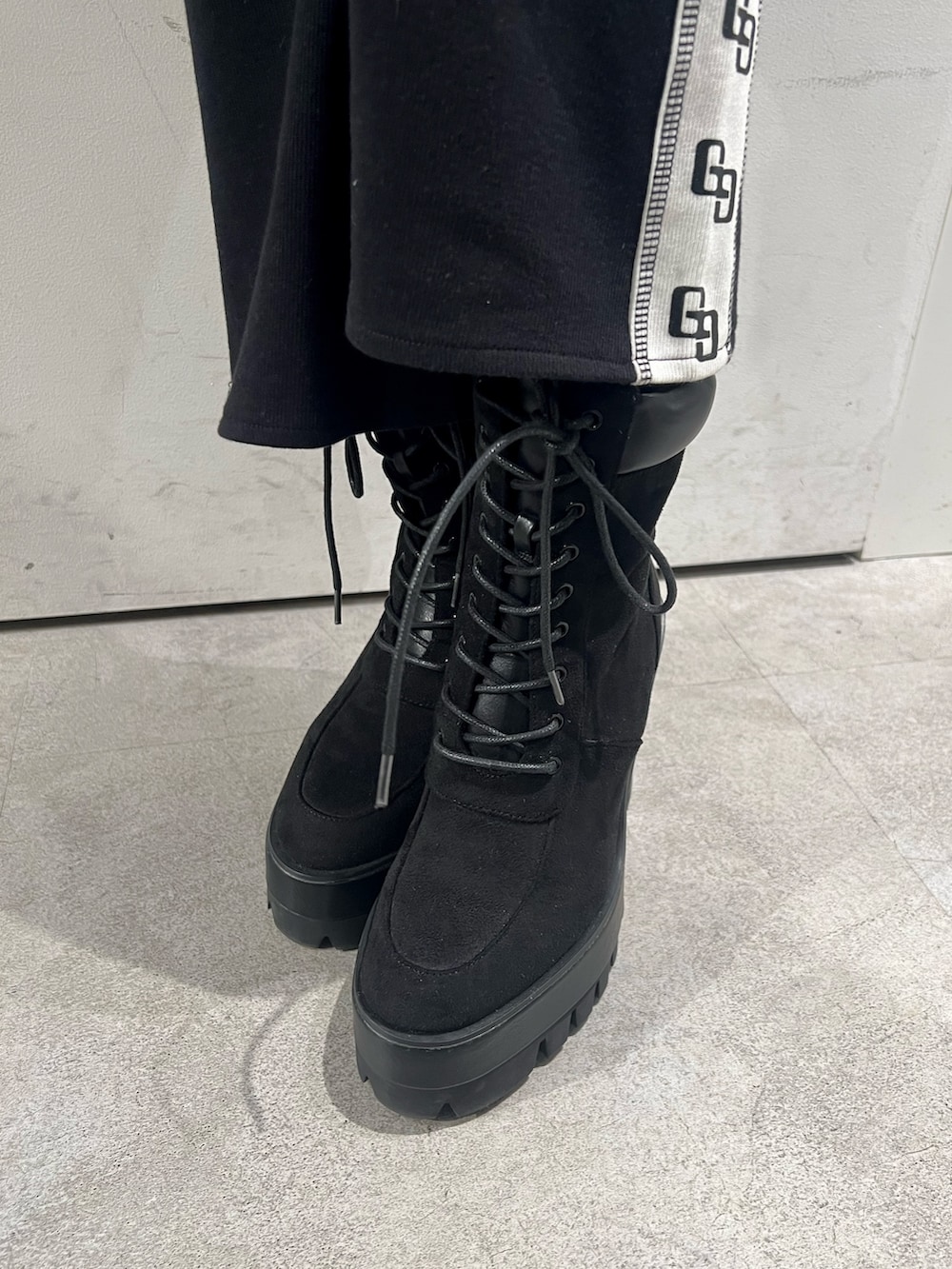 ブラック系のその他パンツ、ブラック系のパーカー、ブラック系のブーツを着用したレディースの冬コーディネートの5枚目の写真