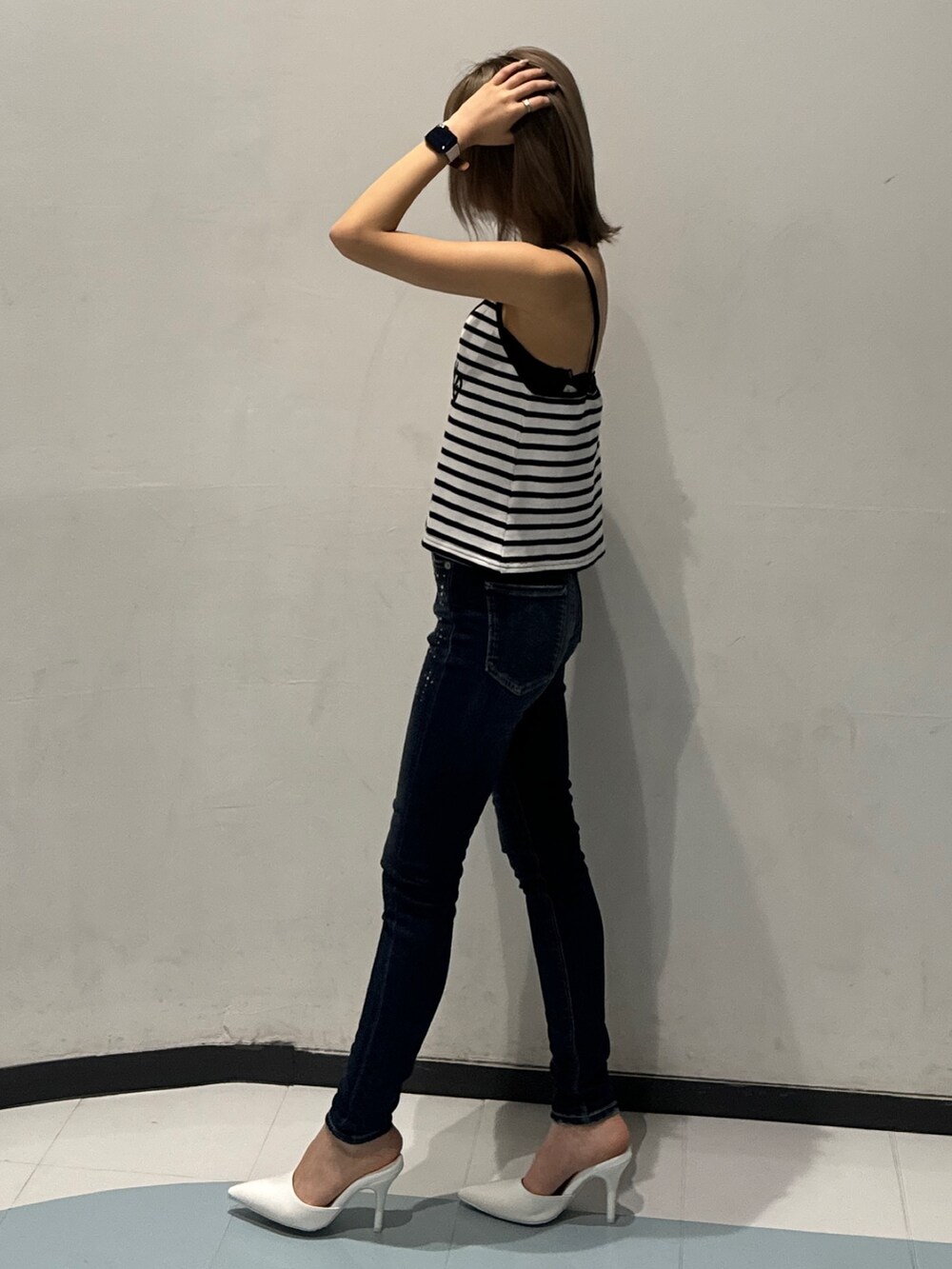 その他のキャミソール、ブルー系のデニムパンツ、ホワイト系のパンプスを着用したレディースの春コーディネートの2枚目の写真
