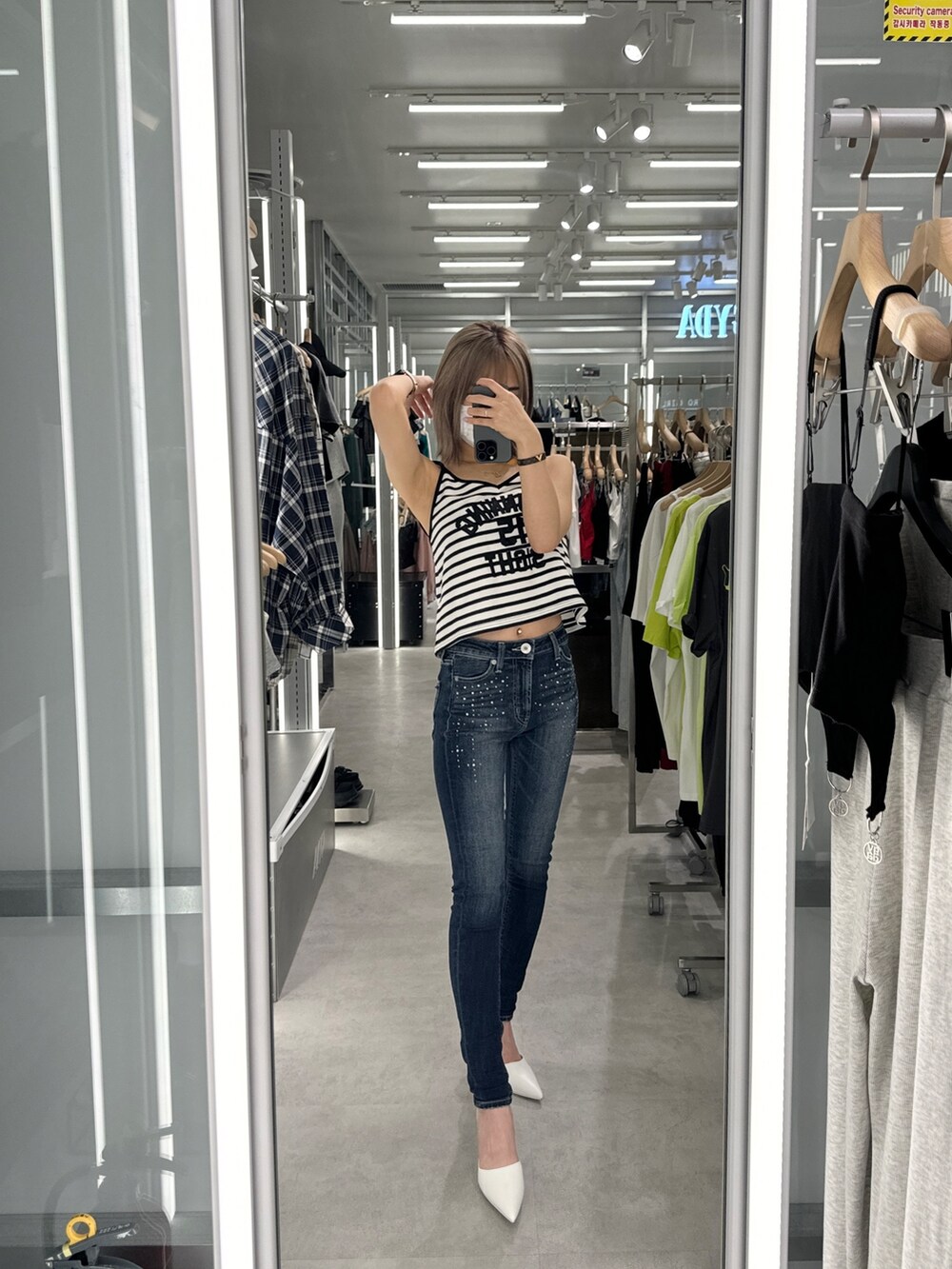 その他のキャミソール、ブルー系のデニムパンツ、ホワイト系のパンプスを着用したレディースの春コーディネートの8枚目の写真