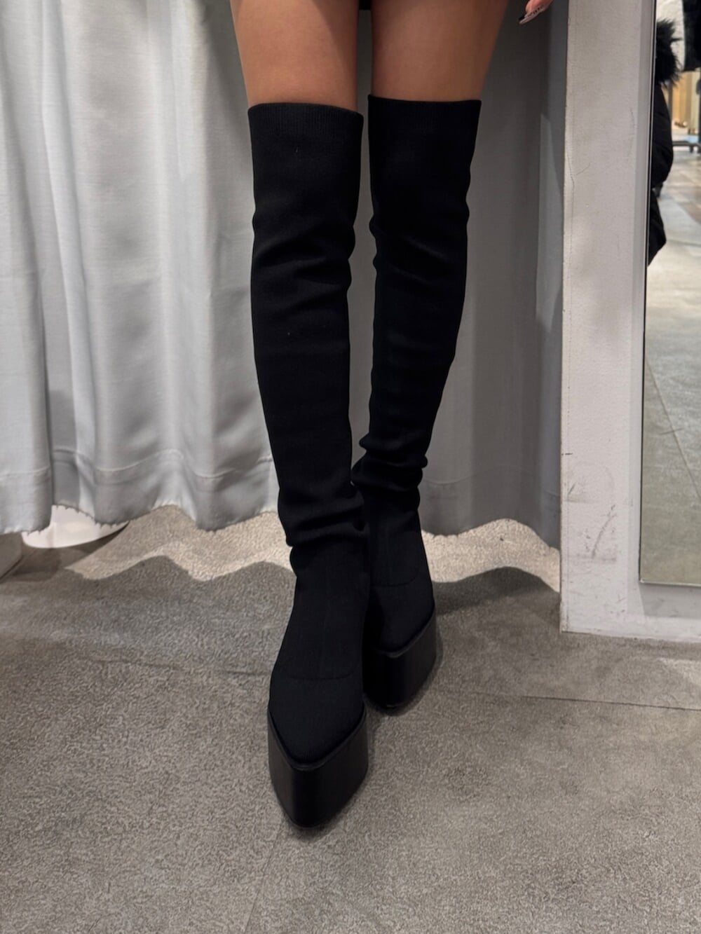 ブラック系のブーツ、ホワイト系のニット/セーターを着用したレディースの冬コーディネートの5枚目の写真