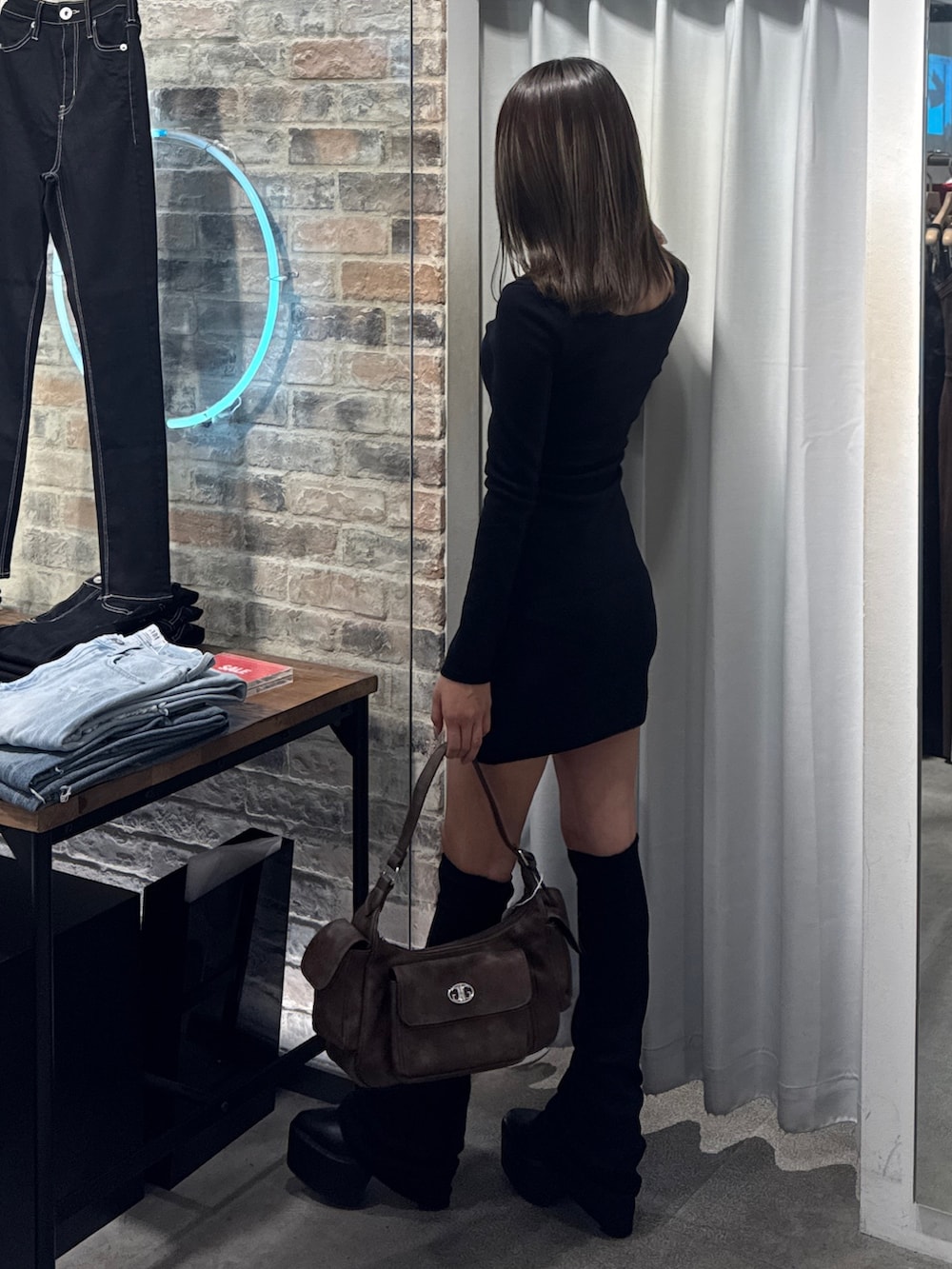 ブラック系のワンピース、ブラック系のブーツを着用したレディースの夏コーディネートの3枚目の写真