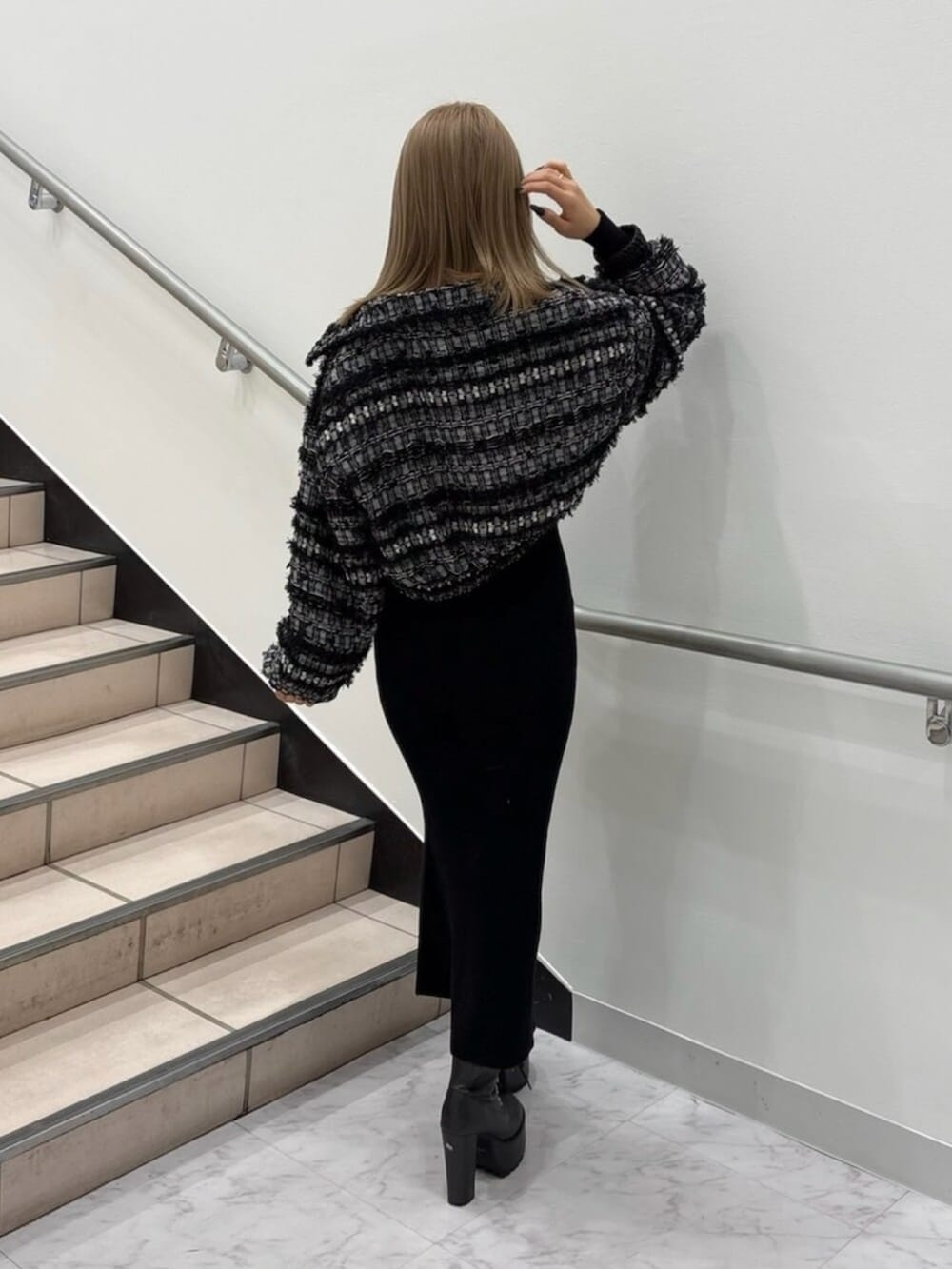 ブラック系のブーツ、ブラック系のその他アウター、ブラック系のワンピースを着用したレディースの春コーディネートの2枚目の写真