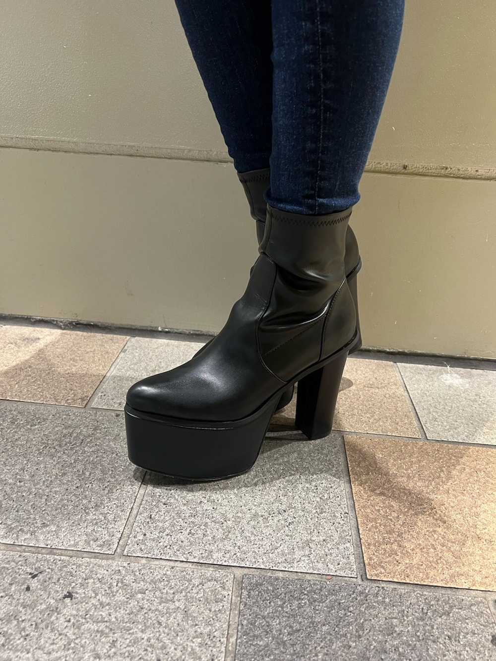 ブラック系のダウンジャケット/コート、ブルー系のデニムパンツ、ブラック系のブーツを着用したレディースの秋コーディネートの4枚目の写真