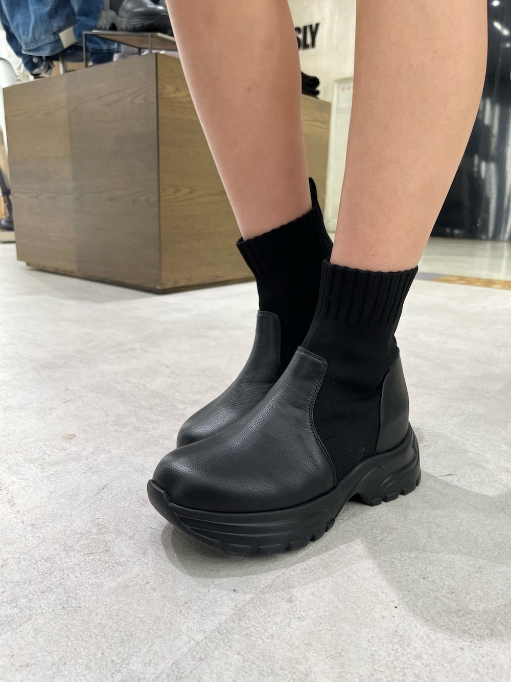 ブラック系のワンピース、ブルー系のデニムジャケット、ブラック系のブーツを着用したレディースの冬コーディネートの6枚目の写真