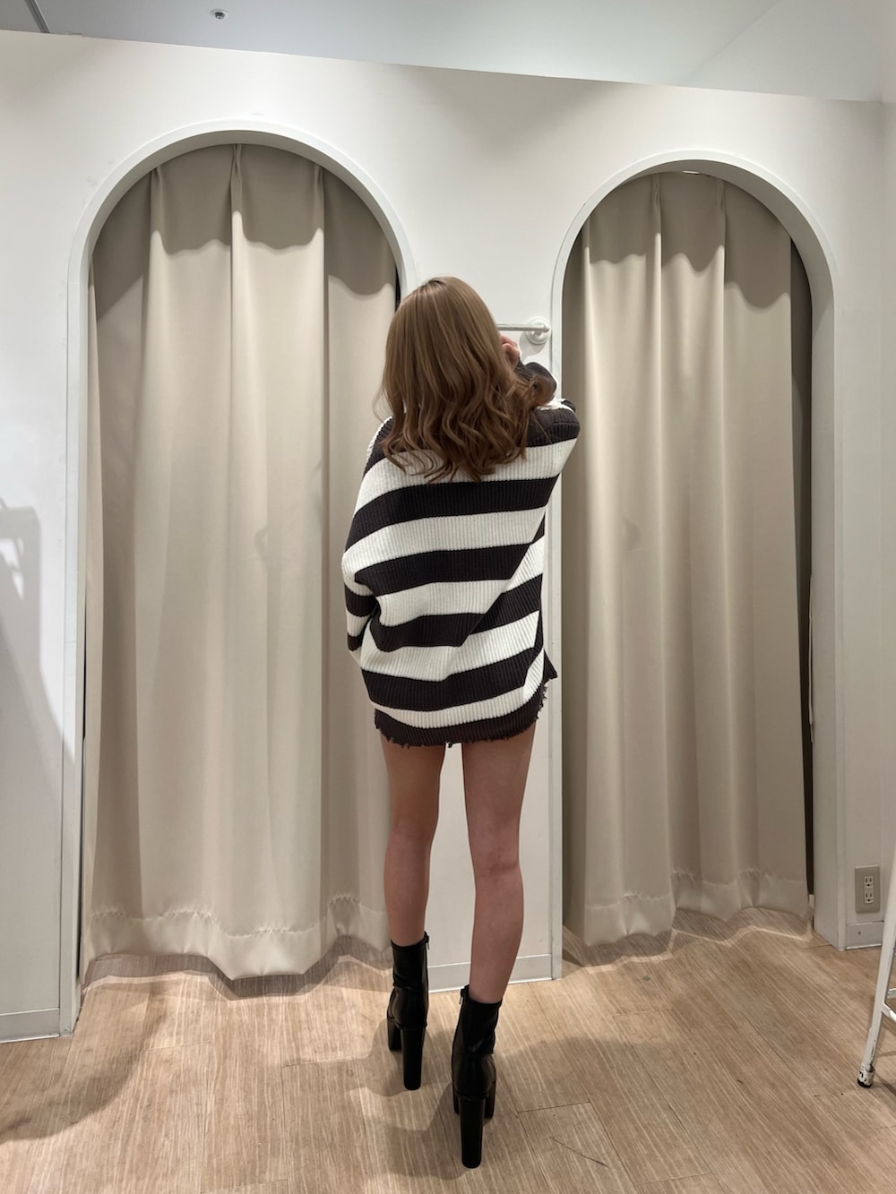 グレー系のカーディガン/ボレロ、ホワイト系のキャミソール、ブルー系のデニムパンツを着用したレディースの春コーディネートの4枚目の写真